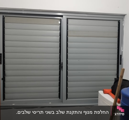 שני תריסים אפורים סגורים עם מסגרת שחורה